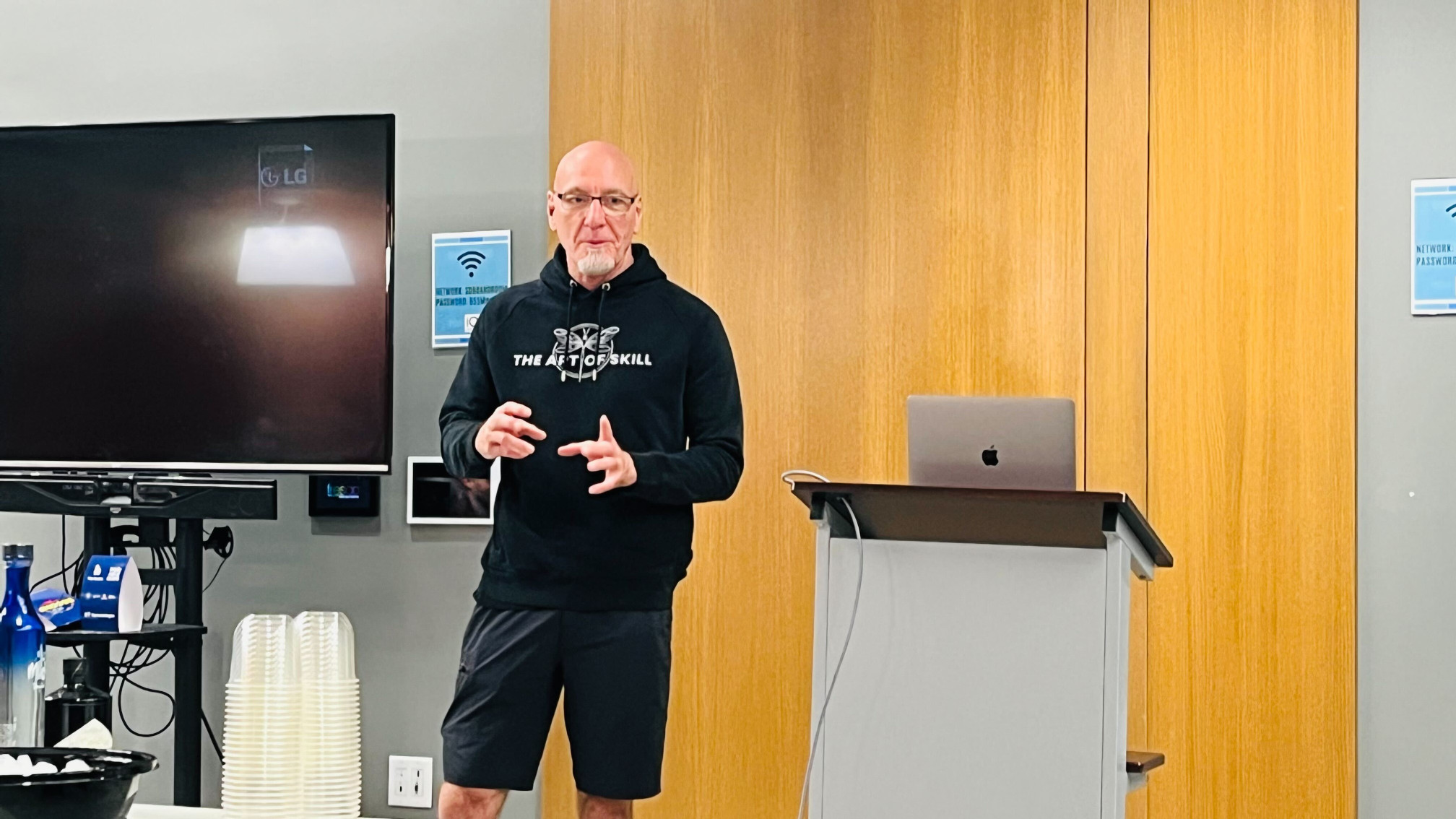 A man gestures with his hands while giving a presentation