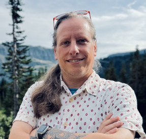 Portrait of Travis Smith with mountains in the background